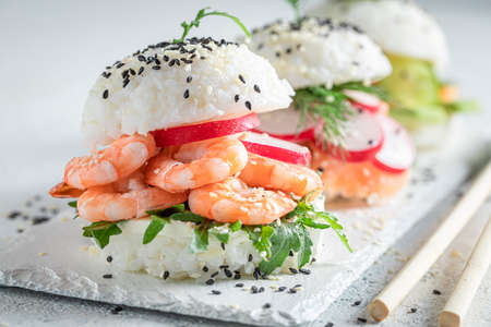 Healthy sush burger with seafood and vegetables sprinkled with sesame. Japanese cuisine.