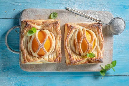 Awesome puff pastry with peaches and mint. Unique yummy cake. French cuisine.の写真素材
