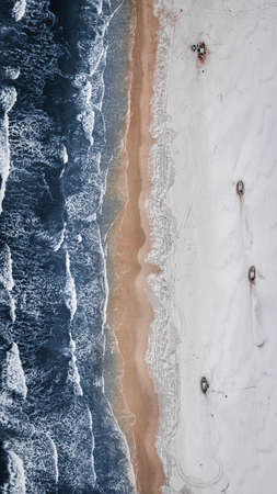 Fishing boats on snowy beach at the Baltic Sea in winter. Aerial view of nature in Poland.の写真素材