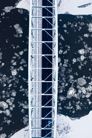 Aerial view of river with floe and snowy bridge. Winter in Poland, Europe