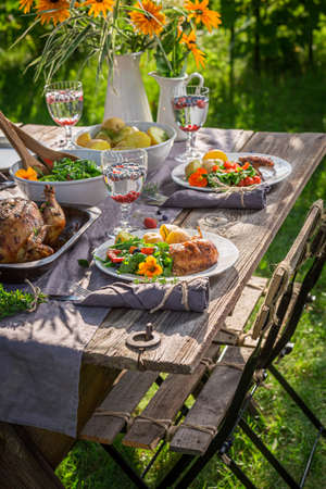 Homemade dinner with salad served in garden. Dinner in garden. Homemade dinner in countryside.の写真素材