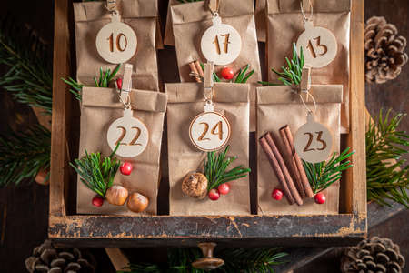 Unique Christmas Advent Calendar made with pine cones and spruce on wooden tableの写真素材