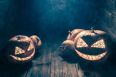 Creepy and strange Jack-o-lantern in wooden shack. Background with copy space for Halloween.の写真素材