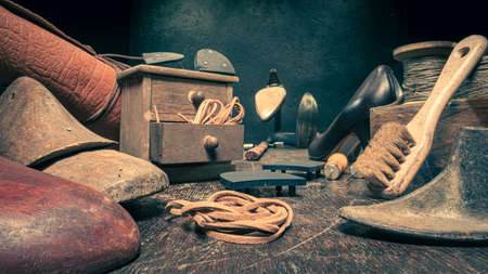 Antique shoemaker workshop with tools, laces and shoes. Antique shoemaker workshop