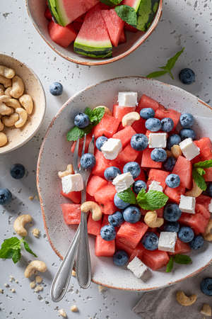 Tasty watermelon salad made of healthy and fresh ingredients. Summer watermelon salad with berries and nutsの写真素材