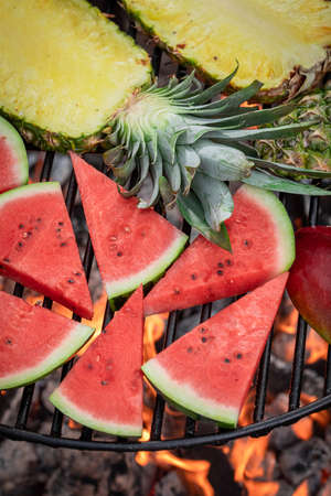 Hot roasted watermelon and pineapple with herbs and spices. Roasted watermelon and pineapple on grill.の写真素材