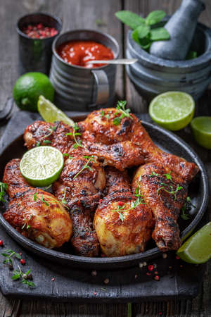 Spicy roasted chicken leg on metal grill plate. Grilled chicken leg with herbs and spicy spices.の写真素材