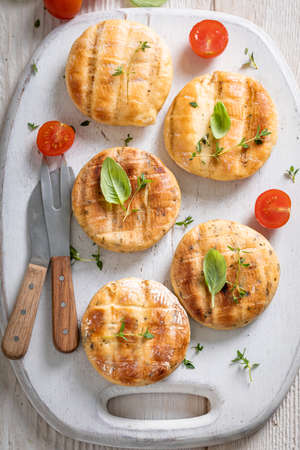 Hot roasted halloumi cheese on a grill with fire. Grilled halloumi cheese served with tomatoes and...