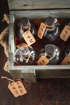 Old and golden whisky stored in the old distillery. Bourbon with ice in a glass in the distillery.