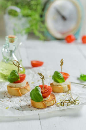 Aromatic and homemade crostini made with mozzarella and tomatoes Traditional Italian lunch.