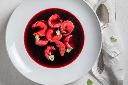 Delicious and spicy beetroot soup served with dumplings. Ukrainian red borsch served with ravioli.の写真素材