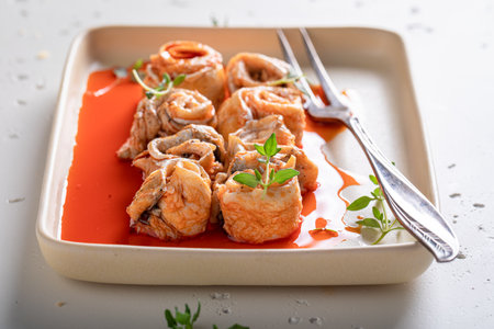 Sour and homemade marinated rollmops with onions. Fish marinated with red sauce.の写真素材