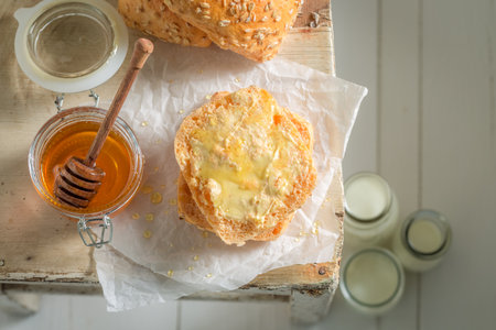 Sweet and homemade wholemeal buns for breakfast. Breakfast with milk and honey.の写真素材