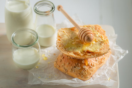 Healthy and sweet wholemeal buns in the morning. Breakfast with milk and honey.の写真素材