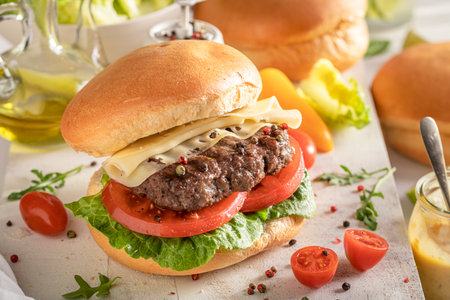 Healthy grilled hamburger baked on a grilled. Grill cheeseburger with vegetables and bun.の写真素材