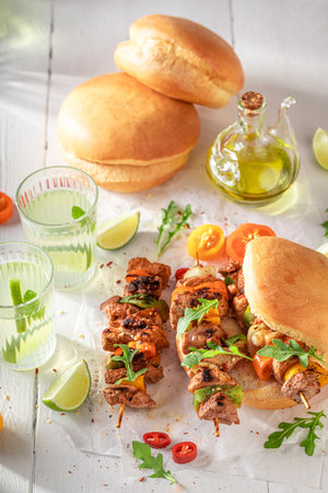 Grilled shashlik with bun vegetables and lemonade. Grilled skewer with vegetables and meat.の写真素材