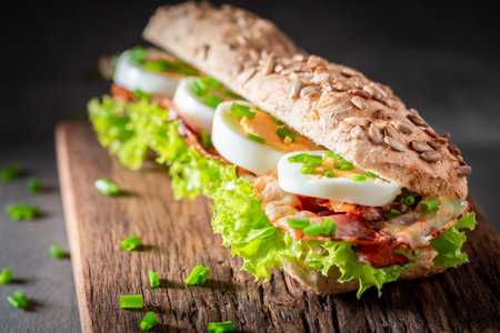 Tasty and homemade sandwich with lettuce, bacon and eggs. Spring sandwich with vegetables and egg.の写真素材
