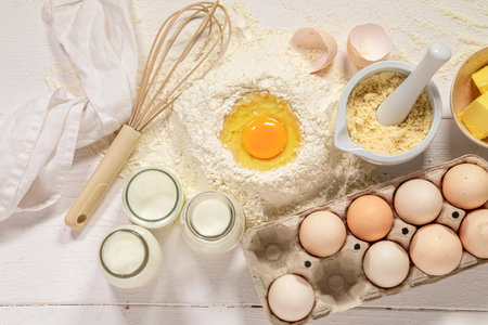 Baking and cooking pastry cake ingredients on white background with copy space, flat lay.
