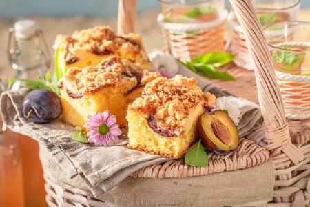 Sweet plum yeast cake served with lemonade on beach. Plum yeast cake on the beach in summer.の写真素材