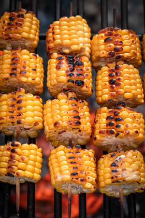 Tasty corncob on grill with melting butter and salt. Grill and baked corn with fire.の写真素材