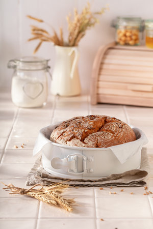 Healthy loaf of round bread freshly baked in home bakery. Rustic loaves of bread.