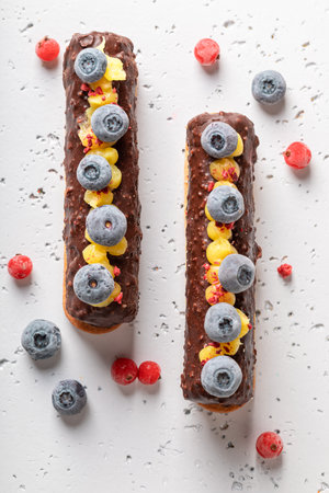 Dark chocolate bar with berries on biscuits on stone table