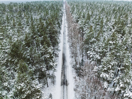 Aerial view of frozen forest and snowy asphalt road in winter, Poland. Nature in winter Poland, Europe.の写真素材