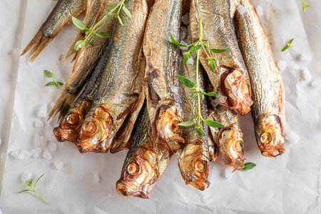 Fresh and salty smoked sprats as popular mediterranean food. Smoked fish marinated with herbs and salt.の写真素材