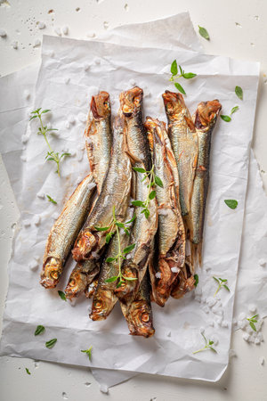 Fresh and salty smoked sprats as healthy snack. Smoked fish marinated with herbs and salt.の写真素材