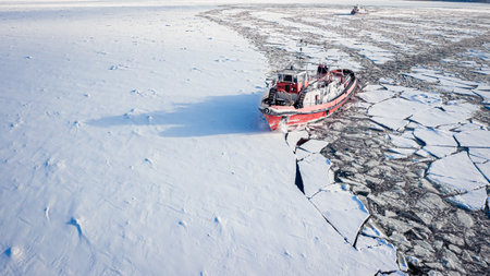 Icebreaker on Vistula River crushing ice at winter, Poland. Aerial view of nature in winter