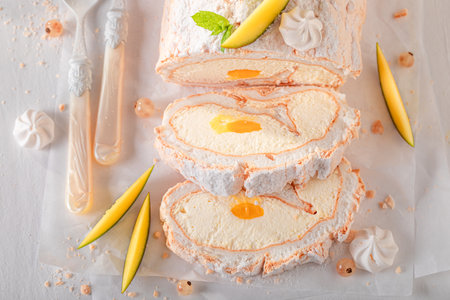 Tasty mango swiss roulade served as sumer dessert. Mango swiss roll with caster sugar and fruit.の写真素材