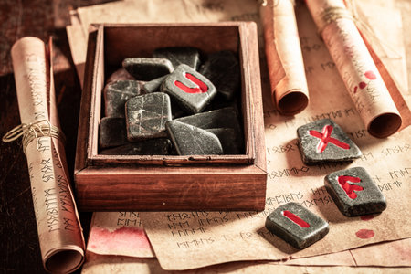 Closeup of antique rune stones with futhark alphabet and old book as a mystical backgroundの写真素材