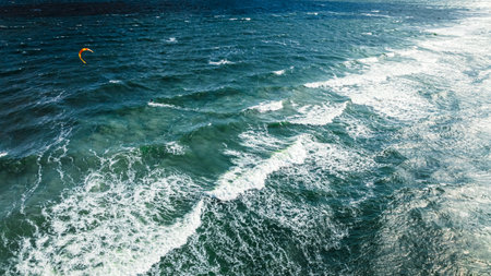 Outstanding kitesurfer riding on big waves at Baltic Sea. Recreation on the Baltic Sea, Tourism in...