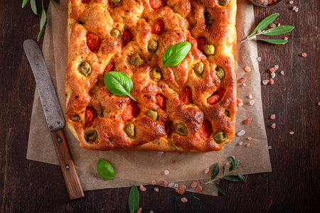 Traditional focaccia with olive oil and cherry tomatoes. Classic Italian cuisine. Focaccia with olives and tomatoes.の写真素材