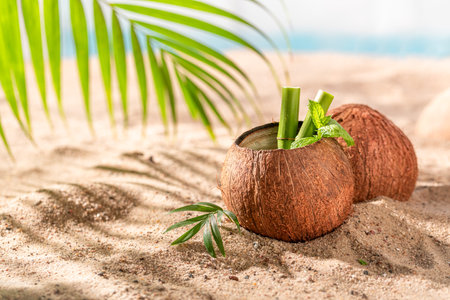 Healthy and fresh coconut milk in shell on tropical beach. Drink served on an exotic beach.の写真素材
