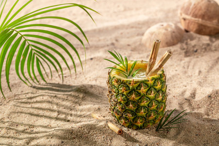 Delicious pinacolada in pineapple served on a sandy island. Drink served on an exotic beach.の写真素材