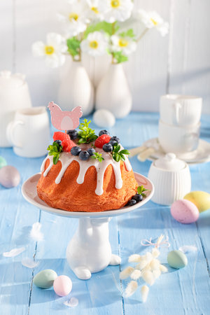 Sweet Easter ring cake surrounded by flowers and eggs. Traditional polish easter dessert.の写真素材