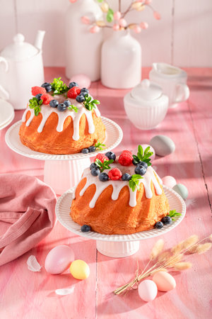 Sweet Easter ring cake on holiday table with decorations. Easter spring background with flowers and easter eggs.の写真素材