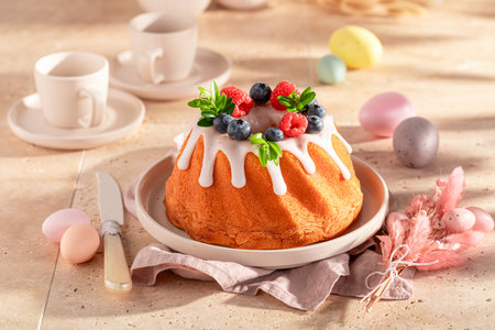 Tasty ring cake for Easter surrounded by flowers and eggs. Cake, Easter eggs and flowers for Easter.の写真素材