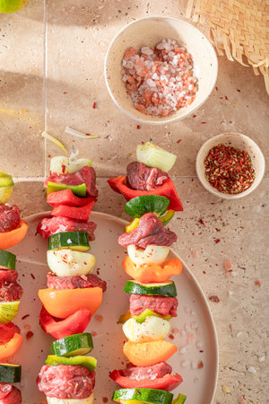 Preparations for grilling tasty skewers as summer snack for bbq. Grilled shashlik with fresh ingredients.の写真素材