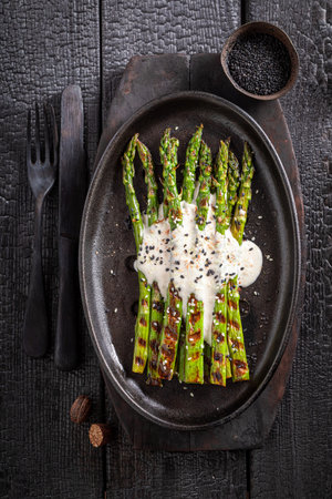 Green roasted asparagus with sesame and lime. Summer grilled asparagus with sauce.の写真素材