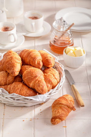 Homemade and fresh french croissants with honey for breakfast. Breakfast with coffee, honey and butter.の写真素材