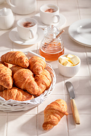 Hot and golden french croissants as a popular snack. Breakfast with coffee, honey and butter.の写真素材