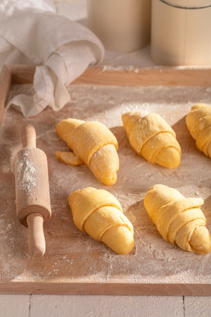 Delicious french croissants cutting from raw dough Raw croissants before baking.の写真素材