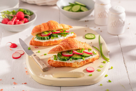 Golden and healthy french croissant with radish and cottage cheese. Croissants as fresh sandwich with vegetables.の写真素材