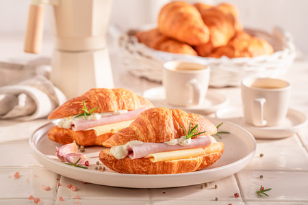 Homemade and hot french croissant served with coffee. Croissants as fresh sandwich with cheese and tomatoes.の写真素材