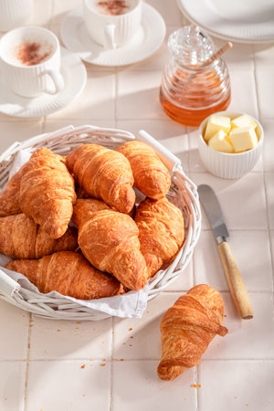 Hot and golden french croissants with honey and butter. Breakfast with coffee, honey and butter.の写真素材