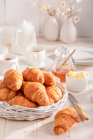 Homemade and fresh french croissants made of puff pastry. Breakfast with coffee, honey and butter.の写真素材