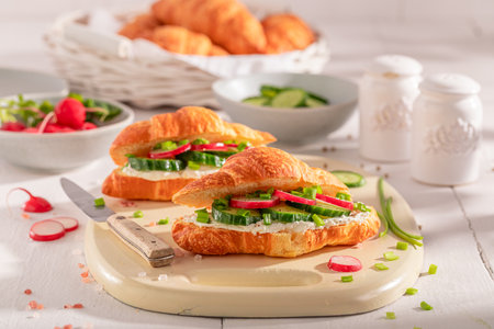Golden and healthy french croissant in spring morning. Croissants as fresh sandwich with vegetables.の写真素材