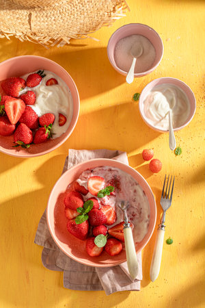 Tasty and creamy strawberries as simple summer snack. Berries with sugar and cream.の写真素材